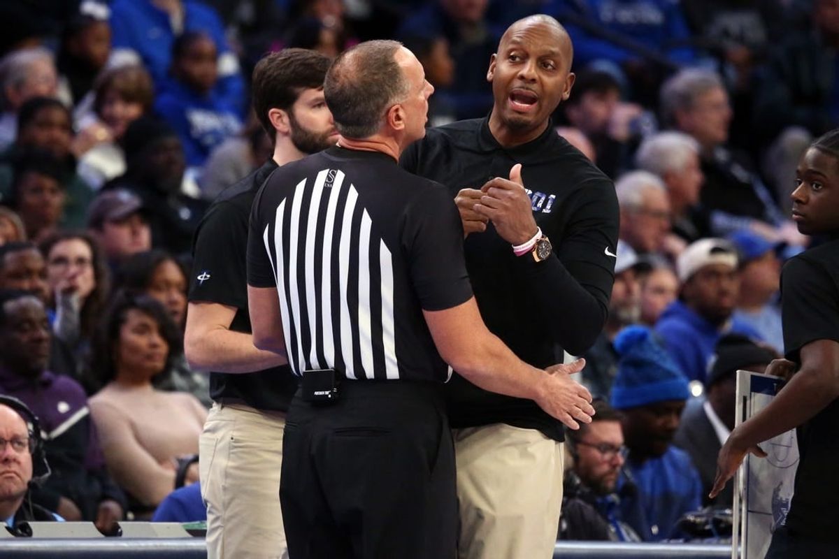 Jan 7, 2024; Memphis, Tennessee, USA; Memphis Tigers head coach  Penny Hardaway (right) is held back by an official during the first half against the Southern Methodist Mustangs at FedExForum.