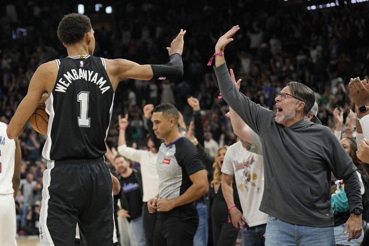 Mar 29, 2024; San Antonio, Texas, USA; San Antonio Spurs forward Victor Wembanyama (1) and a fan react after an overtime victory over the New York Knicks at Frost Bank Center.