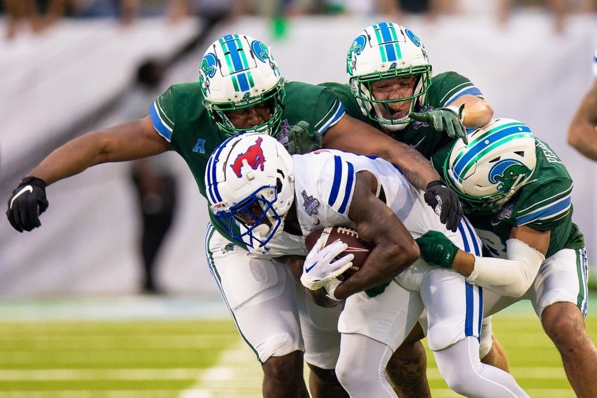 Dec 2, 2023; New Orleans, LA, USA; Southern Methodist Mustangs running back LJ Johnson Jr. (11) is tackled by Tulane Green Wave safety Kam Pedescleaux (8) during the first half at Yulman Stadium.