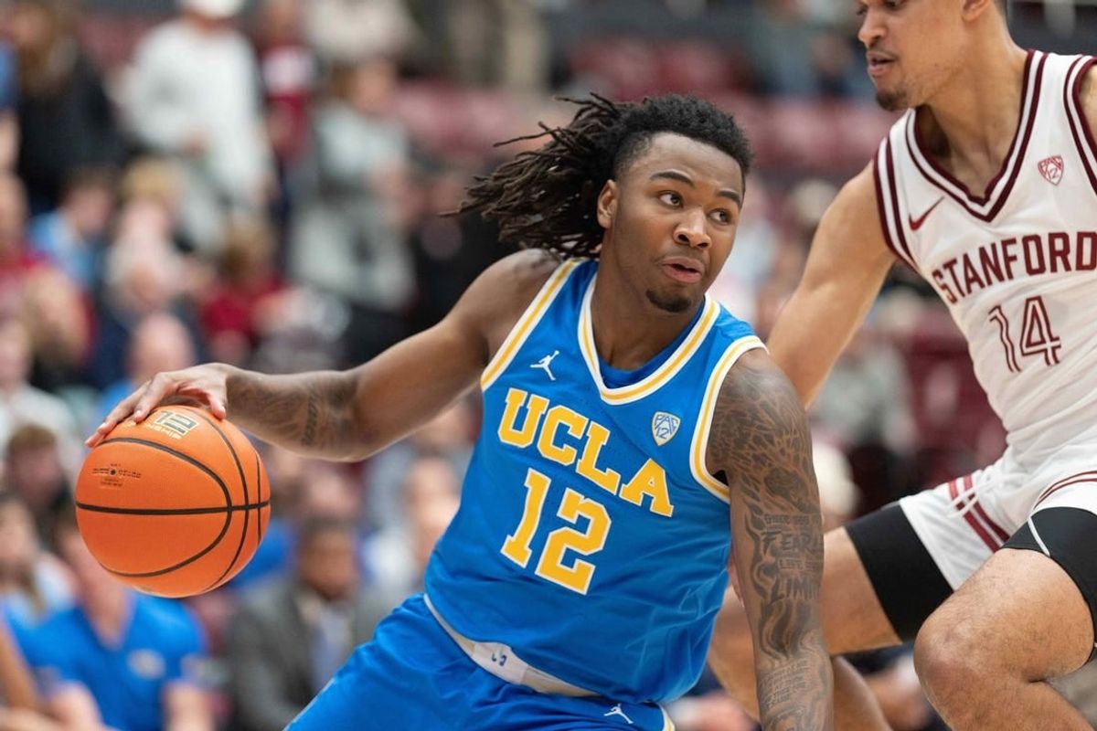 Feb 7, 2024; Stanford, California, USA;  UCLA Bruins guard Sebastian Mack (12) controls the ball during the second half against Stanford Cardinal forward Spencer Jones (14) at Maples Pavilion.