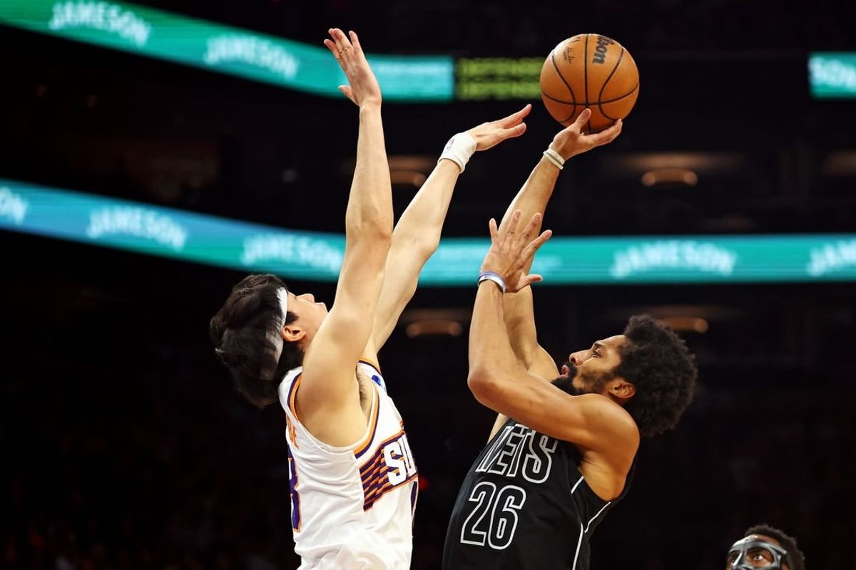 Dec 13, 2023; Phoenix, Arizona, USA; Brooklyn Nets guard Spencer Dinwiddie (26) shoots the ball against Phoenix Suns forward Yuta Watanabe (18) during the second quarter at Footprint Center.
