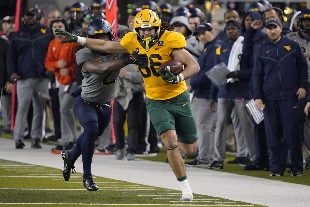 Nov 25, 2023; Waco, Texas, USA; Baylor Bears tight end Jake Roberts (86) runs after the catch past  West Virginia Mountaineers safety Aubrey Burks (2) during the first half at McLane Stadium.
