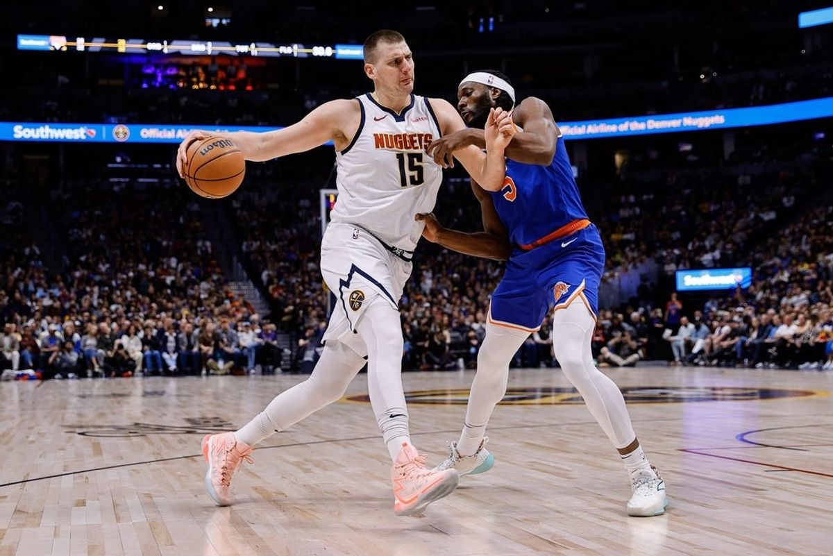 Mar 21, 2024; Denver, Colorado, USA; Denver Nuggets center Nikola Jokic (15) controls the ball as New York Knicks forward Precious Achiuwa (5) guards in the first quarter at Ball Arena.