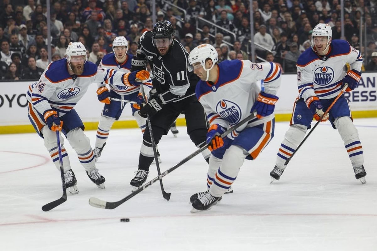 Apr 28, 2024; Los Angeles, California, USA; Edmonton Oilers defensemen Evan Bouchard (2) steals the puck from Los Angeles Kings center Anze Kopitar (11) in the second period of game four of the first round of the 2024 Stanley Cup Playoffs at Crypto.com Arena.