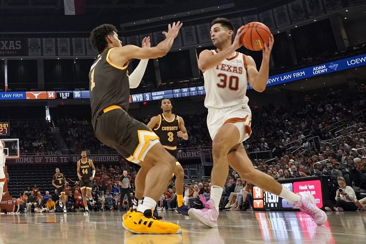 Nov 26, 2023; Austin, Texas, USA; Texas Longhorns forward Brock Cunningham (30) drives to the basket while defended by Wyoming Cowboys guard Brendan Wenzel (1) during the second half at Moody Center.