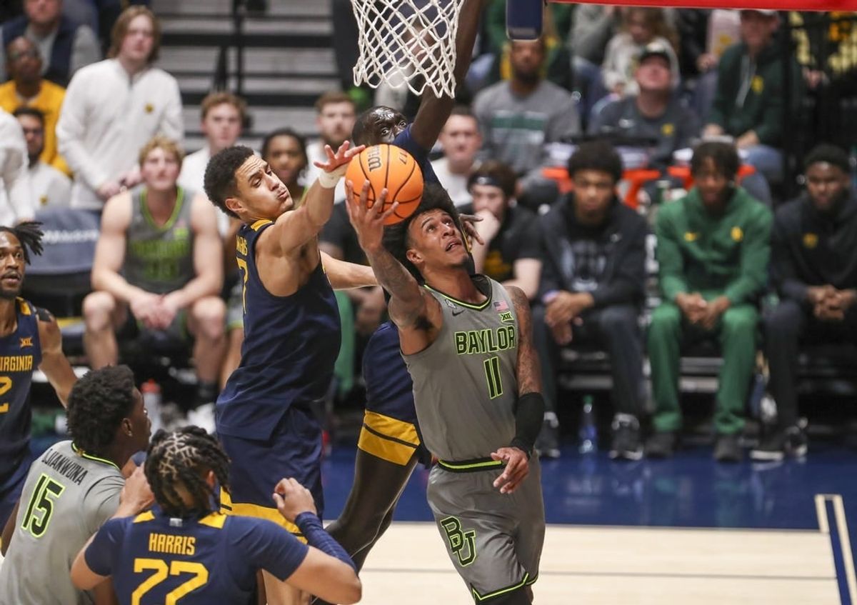 Feb 17, 2024; Morgantown, West Virginia, USA; Baylor Bears forward Jalen Bridges (11) shoots in the lane against West Virginia Mountaineers center Jesse Edwards (7) during the second half at WVU Coliseum.