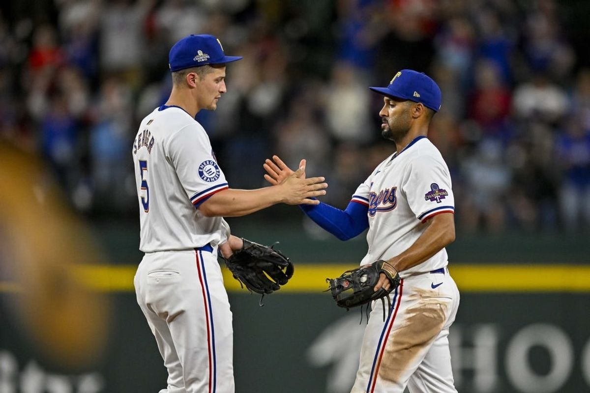Apr 10, 2024; Arlington, Texas, USA; Texas Rangers shortstop Corey Seager (5) and second baseman Marcus Semien (2) celebrate after the Rangers defeat the Oakland Athletics at Globe Life Field.