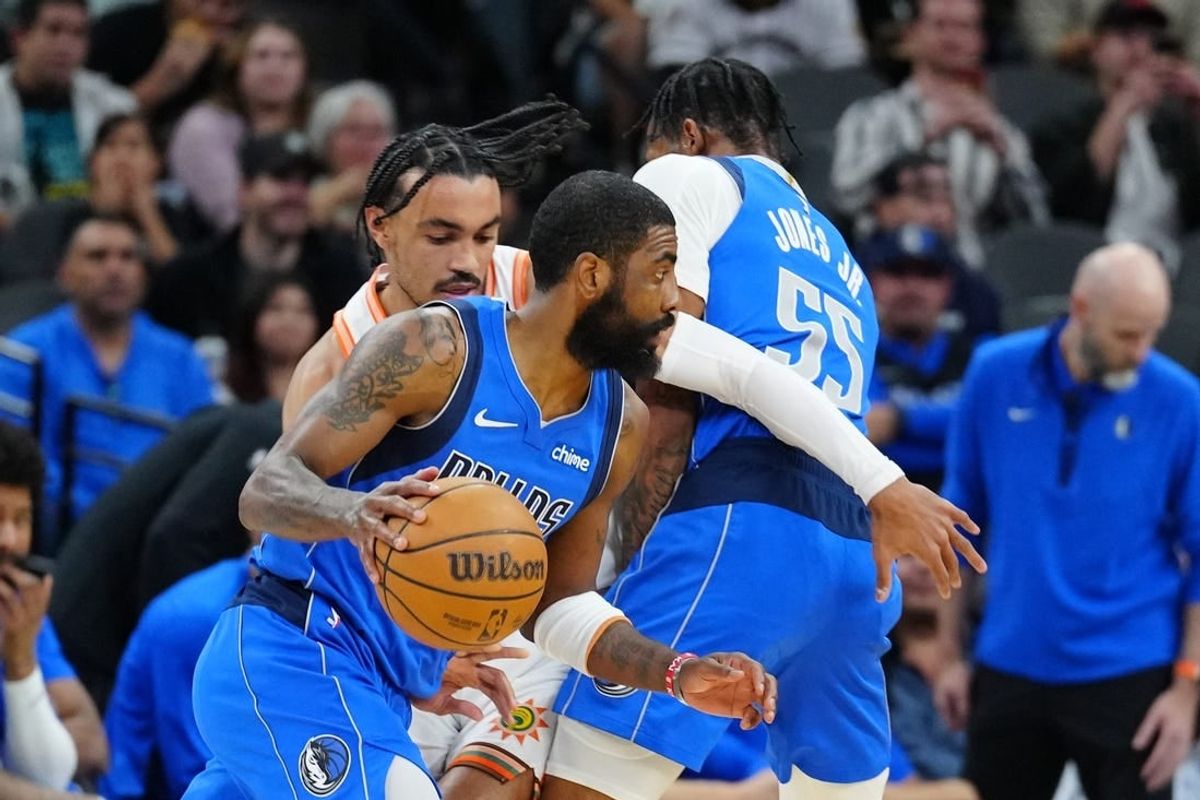 Mar 19, 2024; San Antonio, Texas, USA;  Dallas Mavericks guard Kyrie Irving (11) dribbles past San Antonio Spurs guard Tre Jones (33) in the first half at Frost Bank Center.