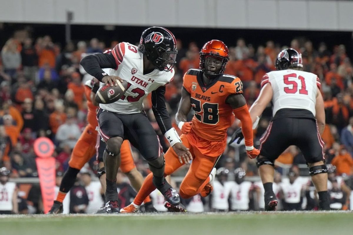 Sep 29, 2023; Corvallis, Oregon, USA; Utah Utes quarterback Nate Johnson (13) scrambles under pressure from Oregon State Beavers defensive back Kitan Oladapo (28) during the second half at Reser Stadium.