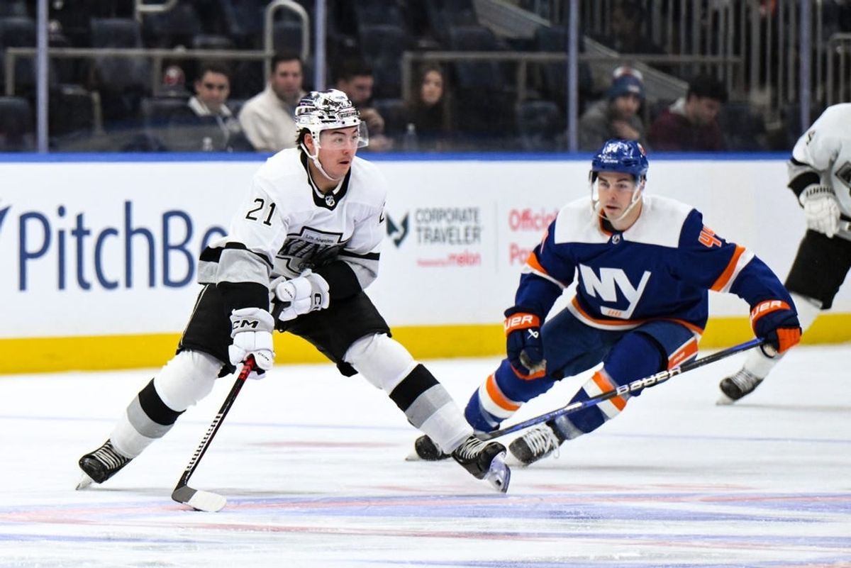 Dec 9, 2023; Elmont, New York, USA; Los Angeles Kings defenseman Jordan Spence (21) skates with the puck while being defended by New York Islanders center Jean-Gabriel Pageau (44) during the first period at UBS Arena.