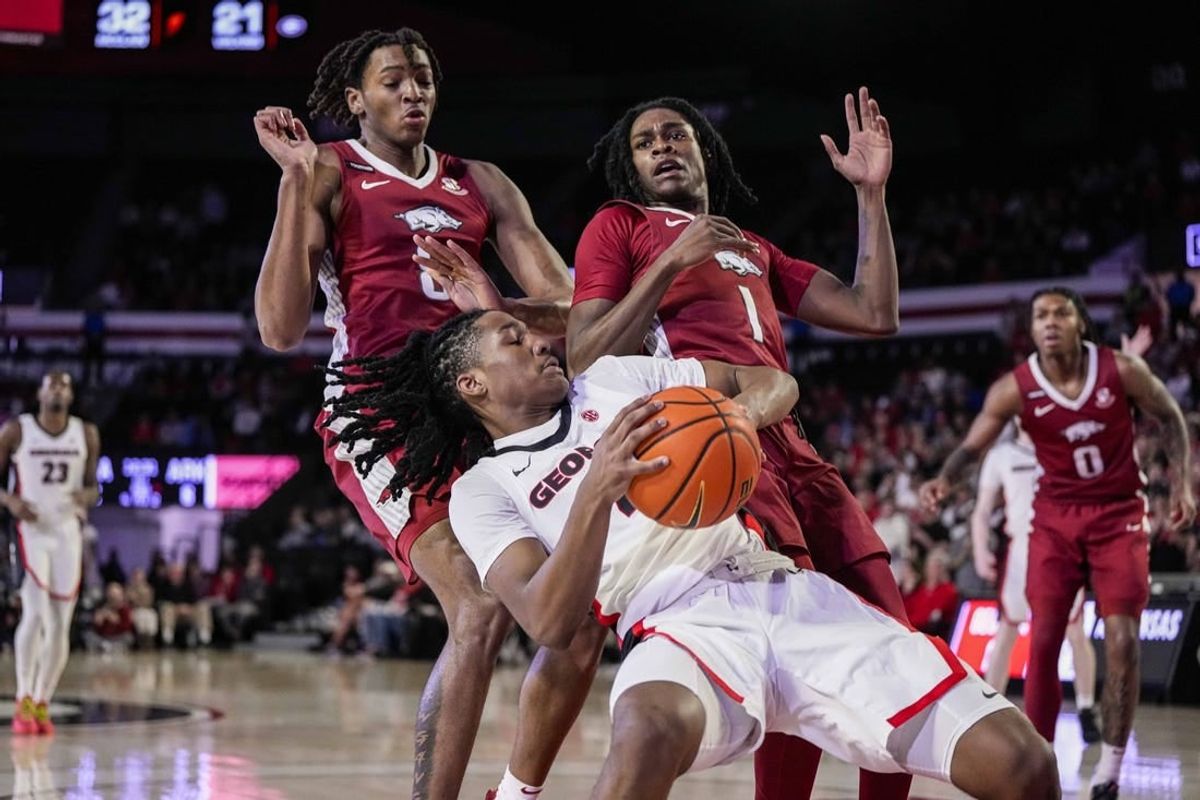 Jan 10, 2024; Athens, Georgia, USA; Georgia Bulldogs guard Silas Demary Jr. (4) controls the ball against Arkansas Razorbacks forward Chandler Lawson (8) and guard Keyon Menifield Jr. (1) during the first half at Stegeman Coliseum.