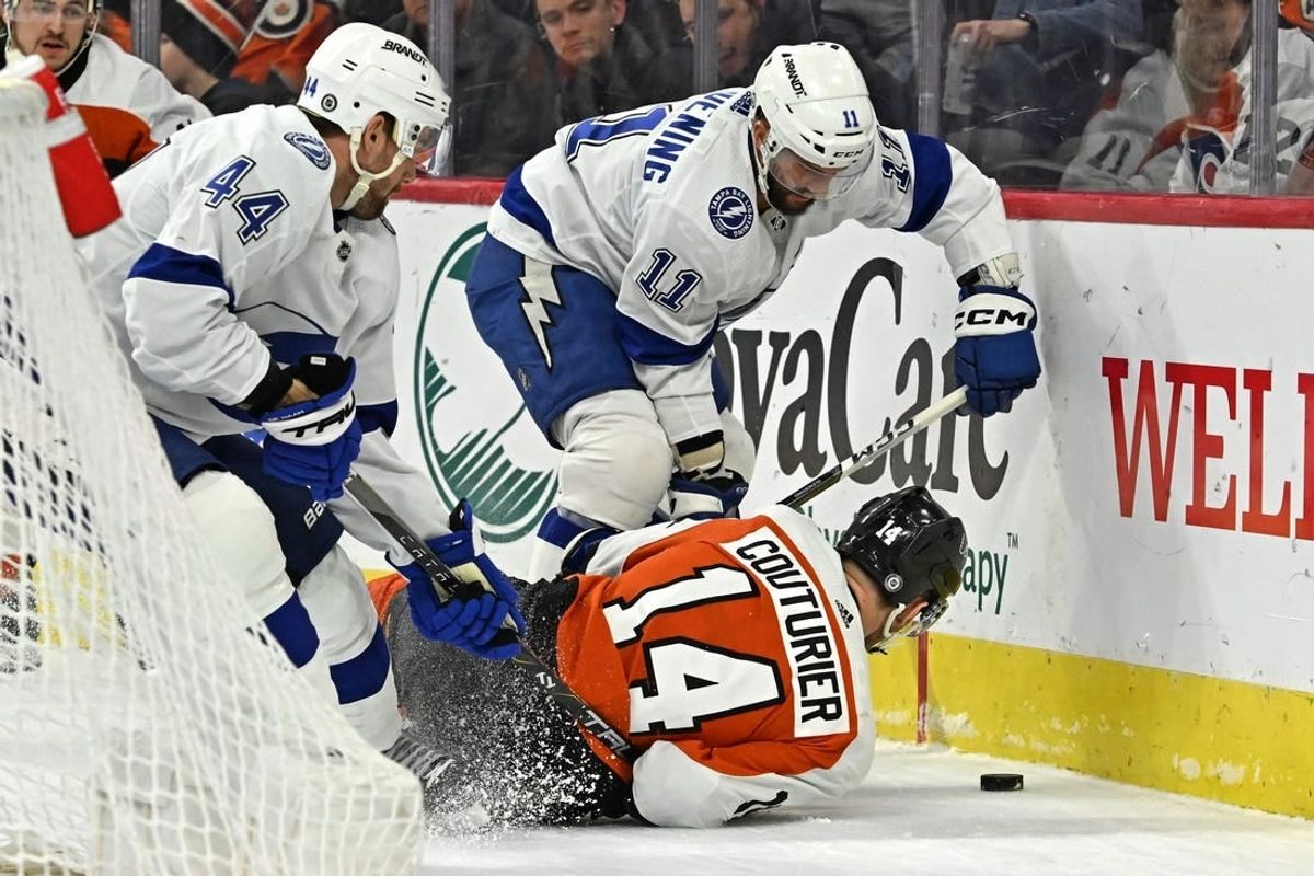 Jan 23, 2024; Philadelphia, Pennsylvania, USA; Philadelphia Flyers center Sean Couturier (14) battles for the puck with Tampa Bay Lightning center Luke Glendening (11) and defenseman Calvin de Haan (44) battle for the puck during the first period at Wells Fargo Center.