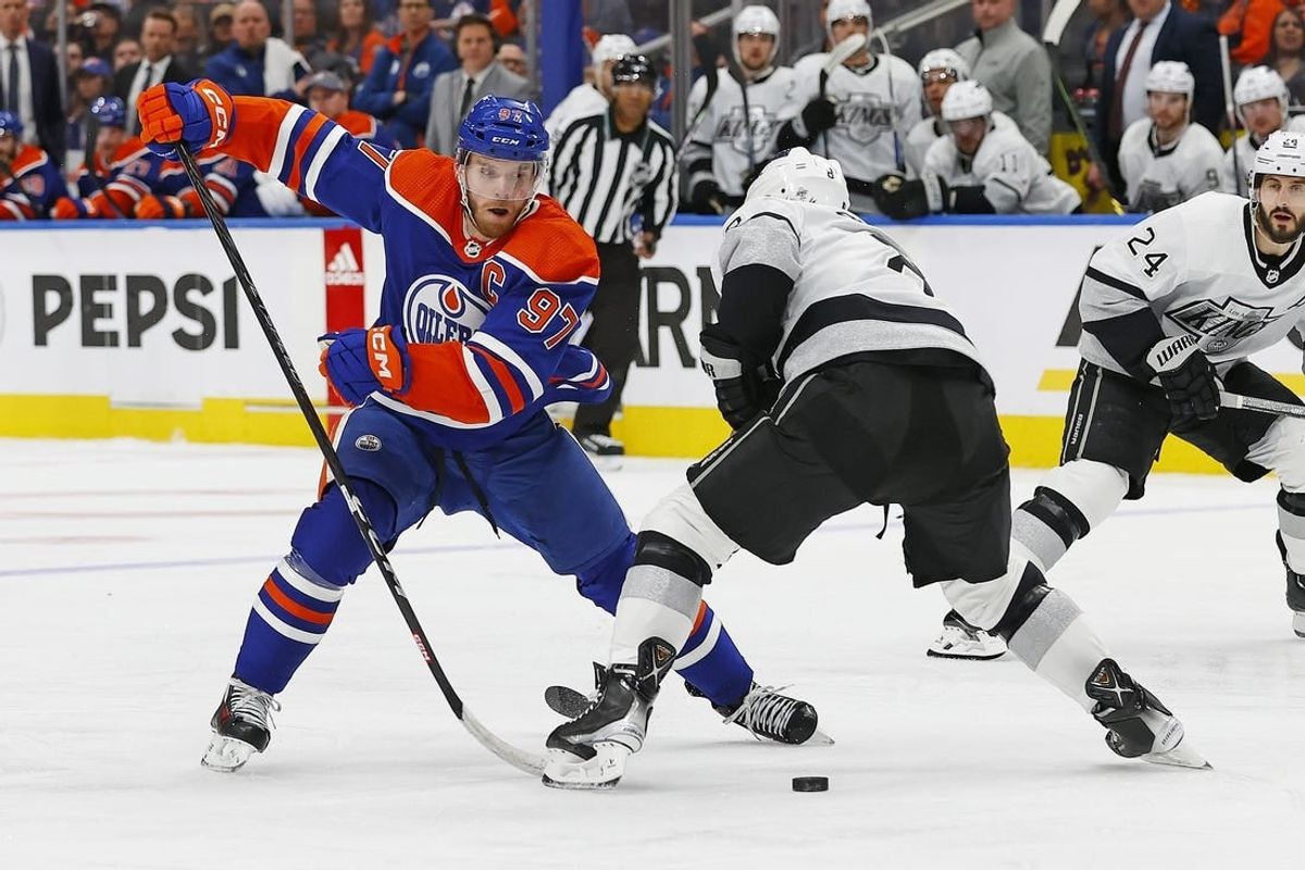 Apr 22, 2024; Edmonton, Alberta, CAN;Edmonton Oilers forward Connor McDavid (97) moves the puck past Los Angeles Kings defensemen Drew Doughty (8) during the third period in game one of the first round of the 2024 Stanley Cup Playoffs at Rogers Place.