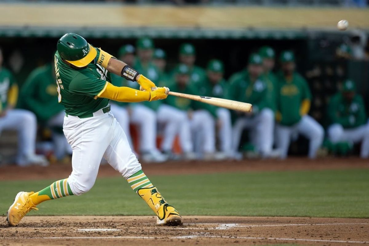 Apr 2, 2024; Oakland, California, USA; Oakland Athletics catcher Shea Langeliers (23) hits a two-run home run against the Boston Red Sox during the second inning at Oakland-Alameda County Coliseum.