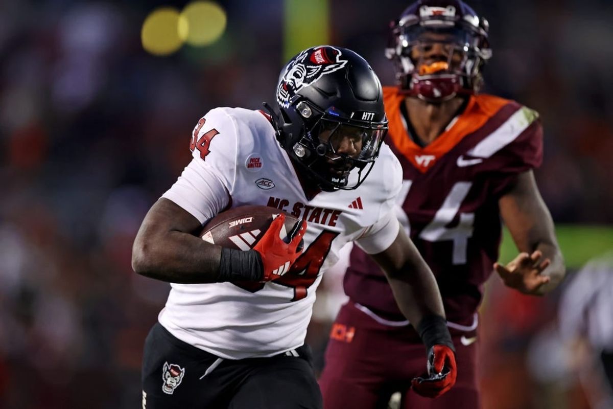 Nov 18, 2023; Blacksburg, Virginia, USA; North Carolina State Wolfpack running back Delbert Mimms III (34) runs the ball against Virginia Tech Hokies linebacker Alan Tisdale (34) during the third quarter at Lane Stadium.