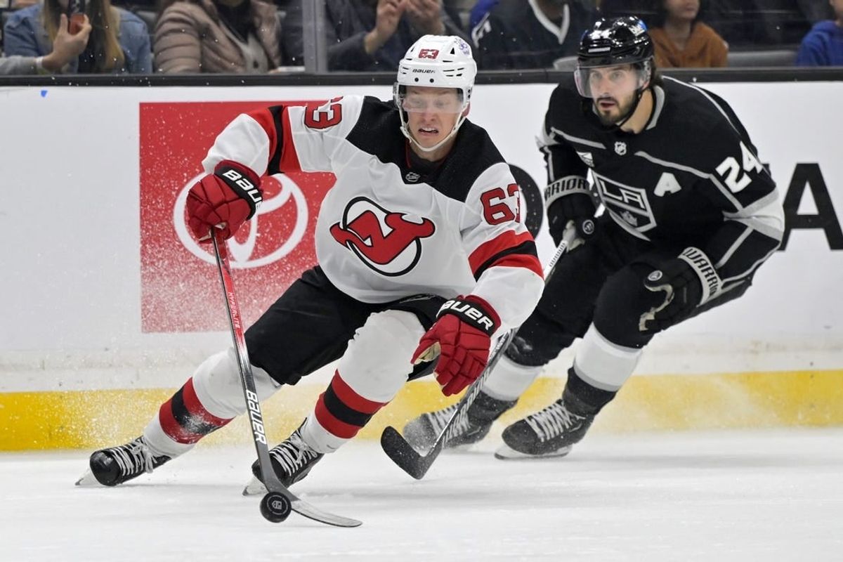 Mar 3, 2024; Los Angeles, California, USA; New Jersey Devils left wing Jesper Bratt (63) keeps the puck away from Los Angeles Kings center Phillip Danault (24) in the second period at Crypto.com Arena.
