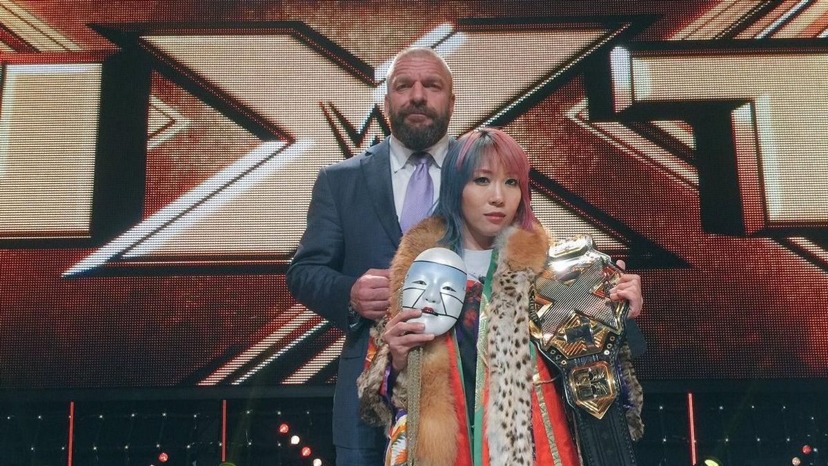 Asuka during her days as NXT champion, with Triple H