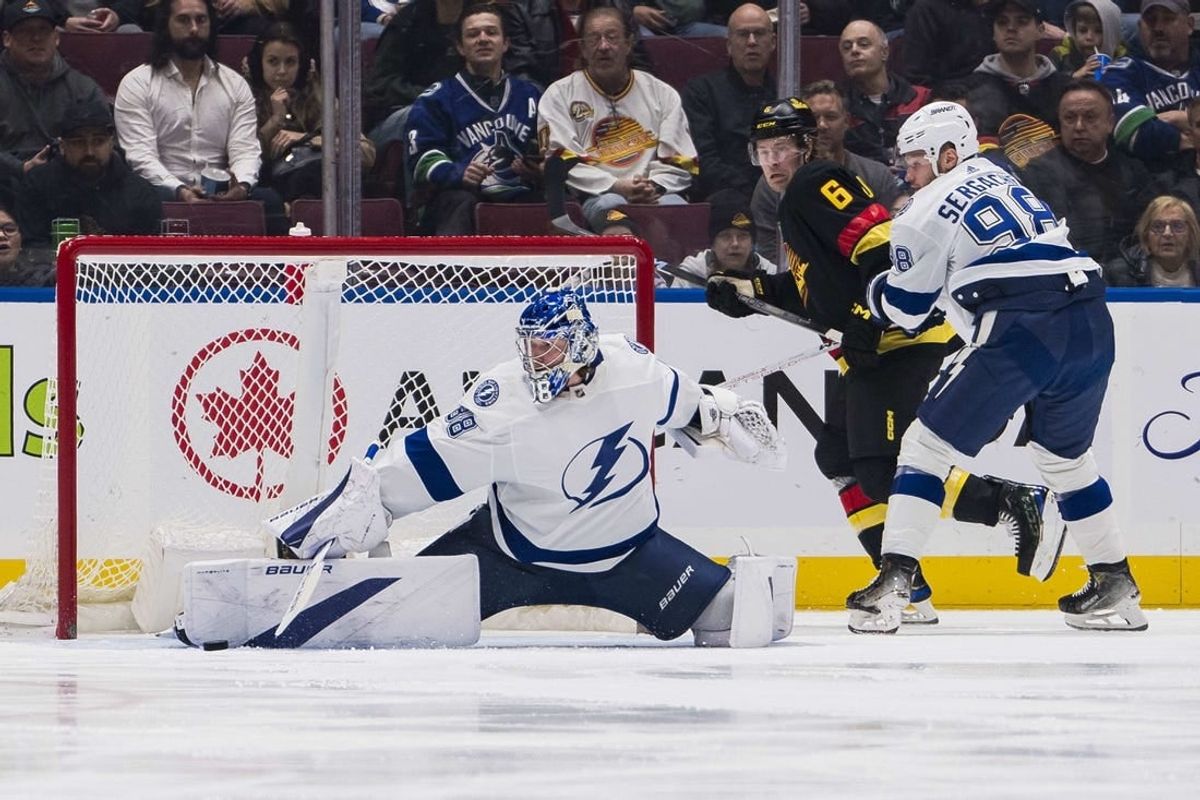 Dec 12, 2023; Vancouver, British Columbia, CAN; Vancouver Canucks forward Brock Boeser (6) and Tampa Bay Lightning defenseman Mikhail Sergachev (98) watch as goalie Andrei Vasilevskiy (88) makes a save in the first period at Rogers Arena.