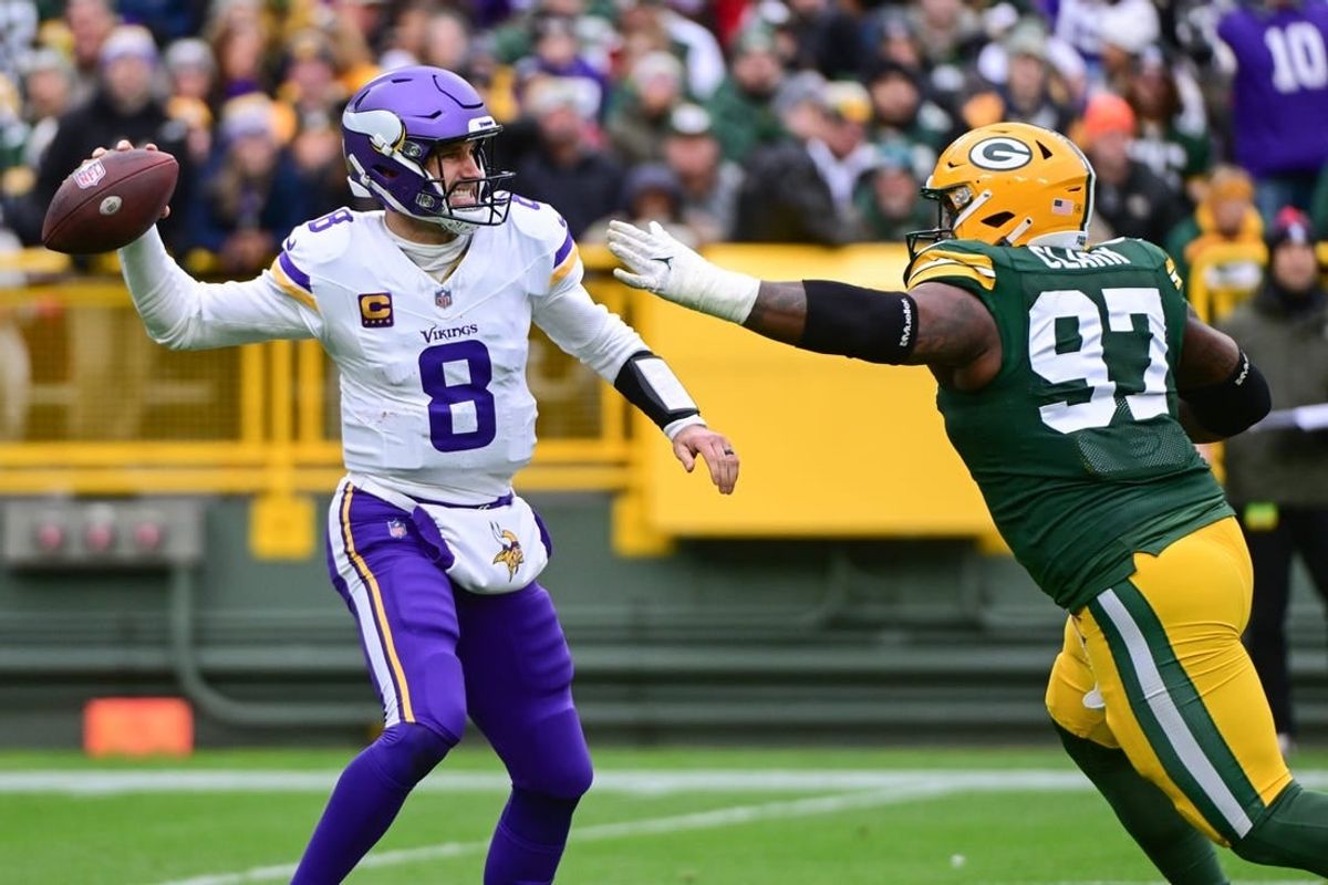 Oct 29, 2023; Green Bay, Wisconsin, USA; Minnesota Vikings quarterback Kirk Cousins (8) gets pressure from Green Bay Packers linebacker Kenny Clark (97) in the first quarter at Lambeau Field.