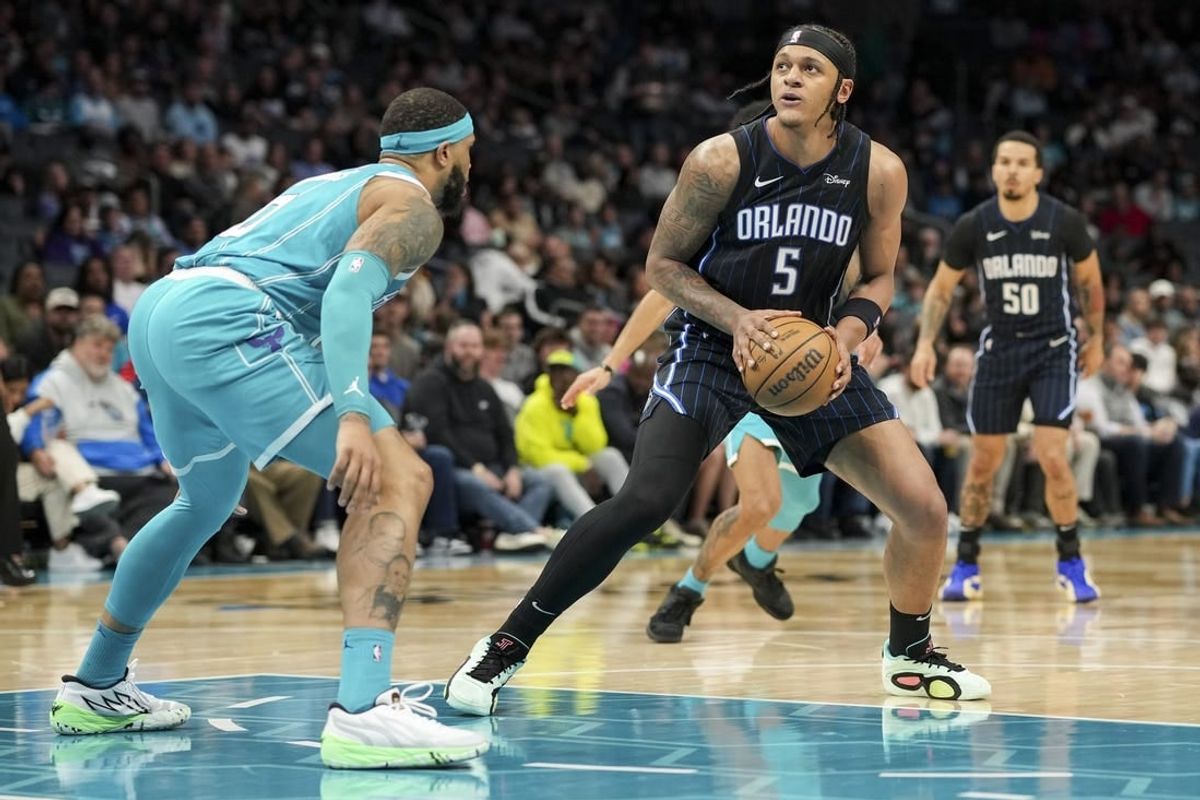 Apr 5, 2024; Charlotte, North Carolina, USA; Orlando Magic forward Paolo Banchero (5) stops and looks for a shot defended by Charlotte Hornets forward Miles Bridges (0) during the second quarter at Spectrum Center.