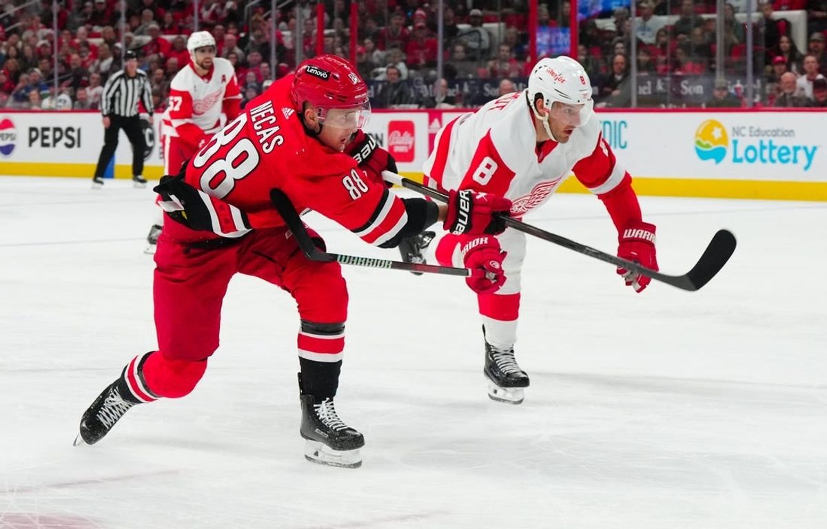 Mar 28, 2024; Raleigh, North Carolina, USA;  Carolina Hurricanes center Martin Necas (88) gets the shot past Detroit Red Wings defenseman Ben Chiarot (8) during the second period at PNC Arena.