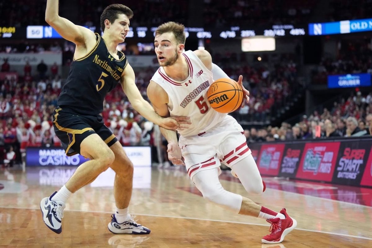 Jan 13, 2024; Madison, Wisconsin, USA; Wisconsin Badgers forward Tyler Wahl (5) dribbles the ball against Northwestern Wildcats guard Ryan Langborg (5) during the second half at the Kohl Center.