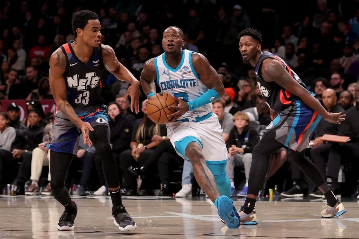 Nov 30, 2023; Brooklyn, New York, USA; Charlotte Hornets guard Terry Rozier (3) drives to the basket against Brooklyn Nets center Nic Claxton (33) and forward Dorian Finney-Smith (28) during the fourth quarter at Barclays Center.