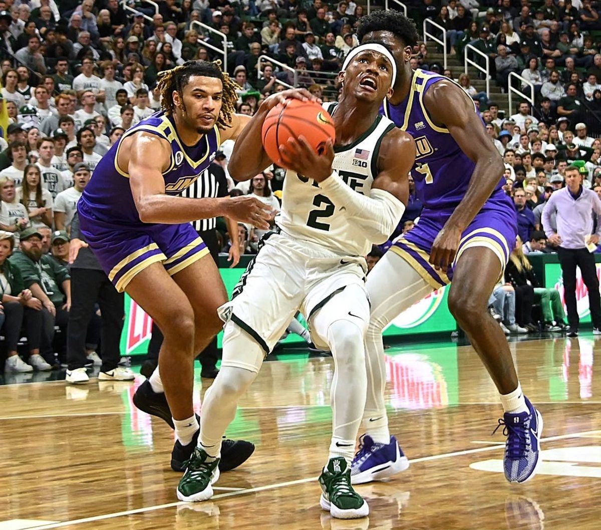 Nov 6, 2023; East Lansing, Michigan, USA; Michigan State Spartans guard Tyson Walker (2) drives through James Madison Dukes forward T.J. Bickerstaff (3) and guard Bryant Randleman (4) during the second half at Jack Breslin Student Events Center.