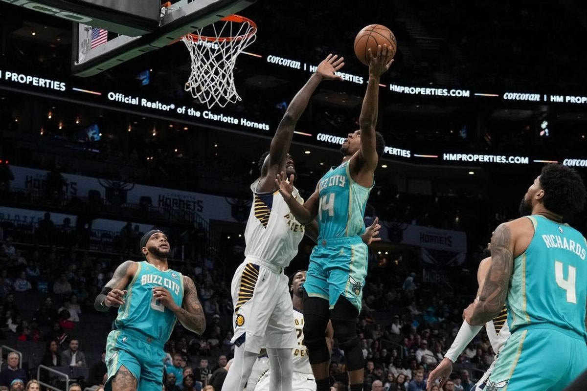 Feb 4, 2024; Charlotte, North Carolina, USA; Charlotte Hornets guard Ish Smith (14) gets a fast break basket defended by Indiana Pacers forward Aaron Nesmith (23) during the first quarter at Spectrum Center.