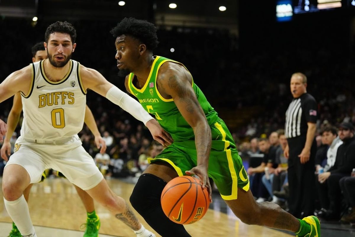 Jan 18, 2024; Boulder, Colorado, USA; Oregon Ducks guard Jermaine Couisnard (5) drives at Colorado Buffaloes guard Luke O'Brien (0) in the first half at the CU Events Center.