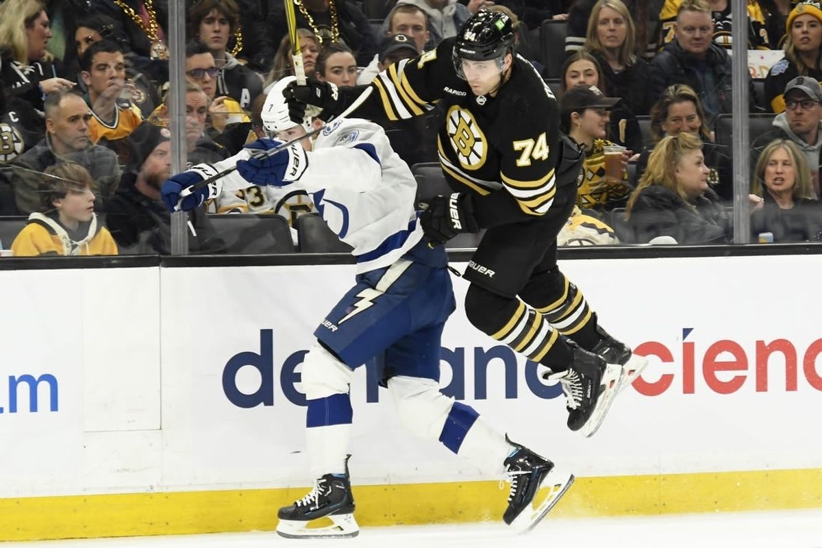 Feb 13, 2024; Boston, Massachusetts, USA;  Boston Bruins left wing Jake DeBrusk (74) leaps by Tampa Bay Lightning defenseman Haydn Fleury (7) during the first period at TD Garden.