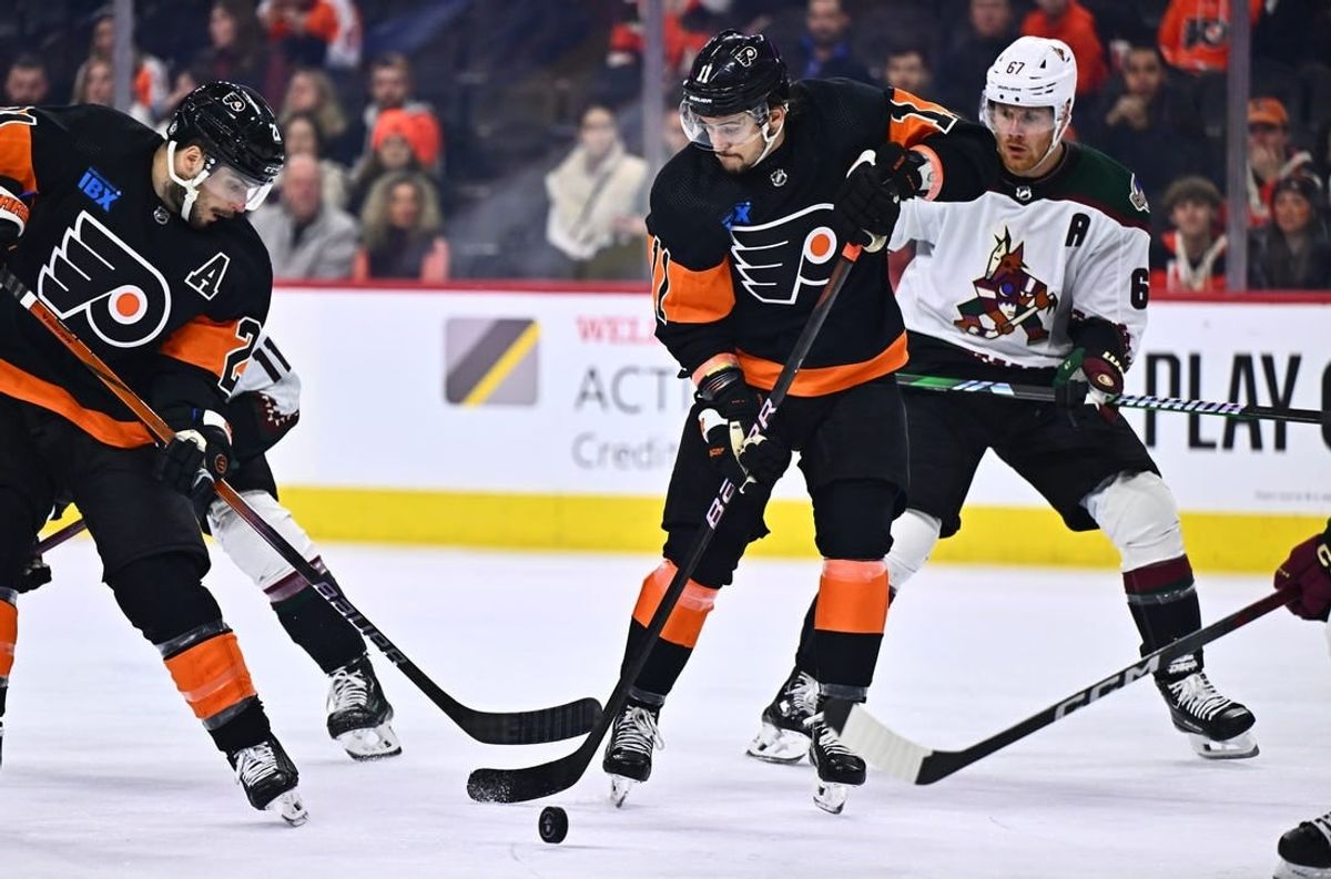 Feb 12, 2024; Philadelphia, Pennsylvania, USA; Philadelphia Flyers right wing Travis Konecny (11) reaches for a loose puck against the Arizona Coyotes in the third period at Wells Fargo Center.