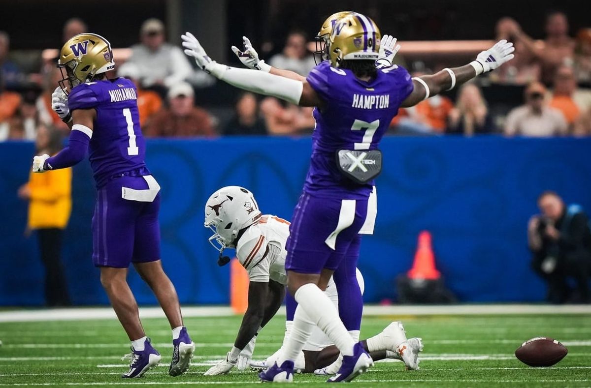 Texas Longhorns wide receiver Xavier Worthy (1) remains on the ground at the Washington Huskies defense, including cornerback Dominique Hampton (7) celebrate stopping a play in the second quarter of the Sugar Bowl College Football Playoff semi-finals at the Ceasars Superdome in New Orleans, Louisiana, Jan. 1, 2024. The Texas Longhorns take on the Washington Huskies for a spot in the College Football Playoff Finals.