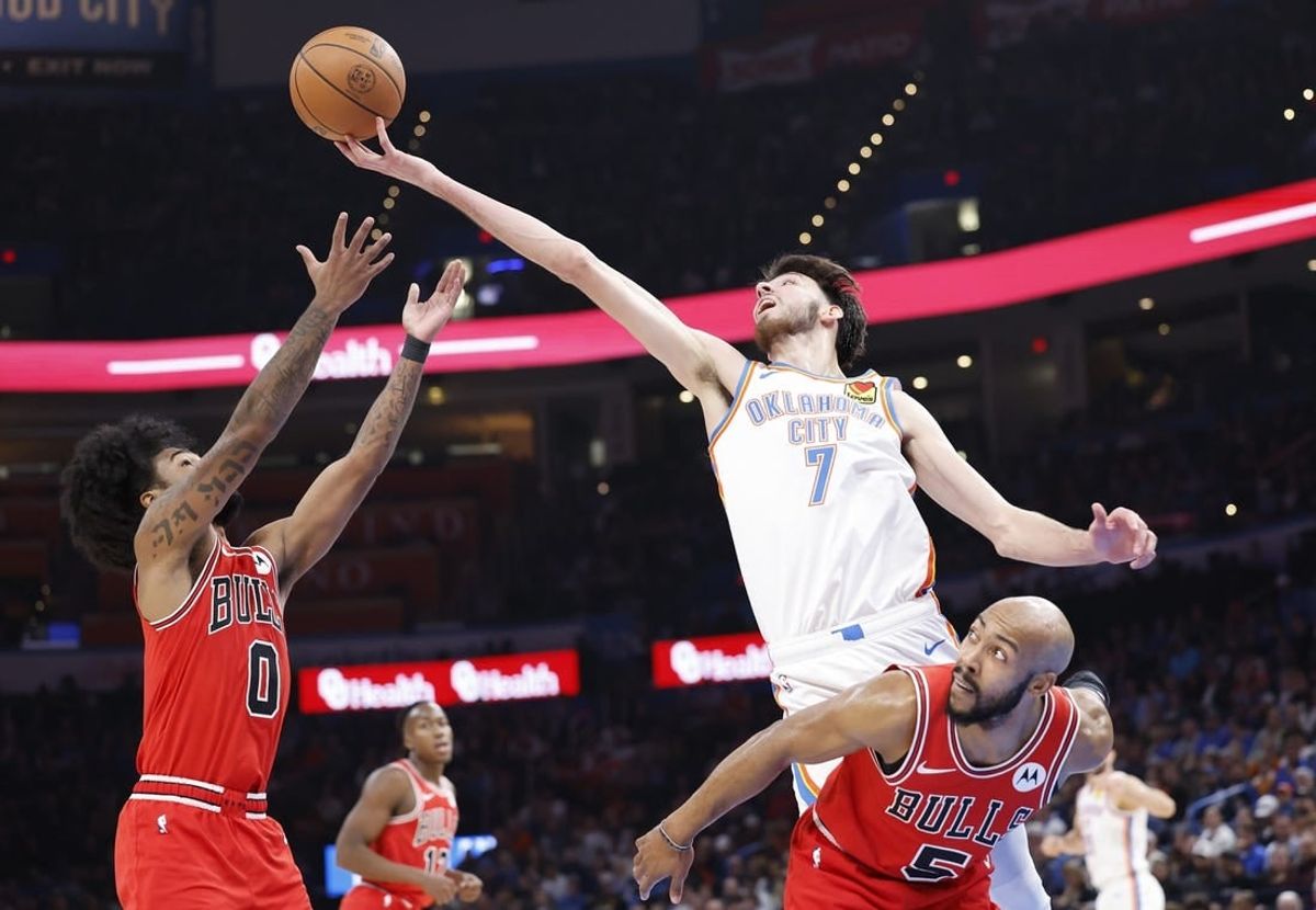 Nov 22, 2023; Oklahoma City, Oklahoma, USA; Oklahoma City Thunder forward Chet Holmgren (7) reaches for a loose ball over Chicago Bulls guard Coby White (0) and guard Jevon Carter (5) during the second quarter at Paycom Center.