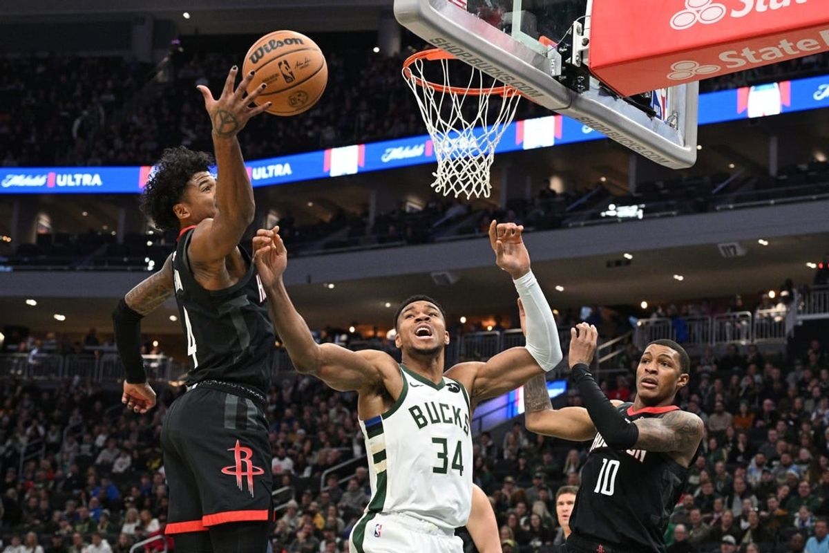 Dec 17, 2023; Milwaukee, Wisconsin, USA; Milwaukee Bucks forward Giannis Antetokounmpo (34) battles for a rebound with Houston Rockets guard Jalen Green (4) in the first half at Fiserv Forum.
