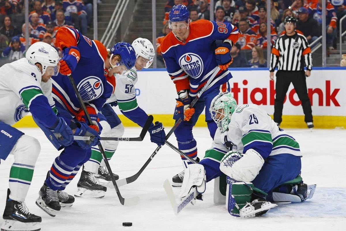 Apr 13, 2024; Edmonton, Alberta, CAN; Edmonton Oilers forward forward Warren Foegele (37) and forward Corey Perry (90) try to get to a loose puck in front of Vancouver Canucks goaltender Casey DeSmith (29) during the first period at Rogers Place.