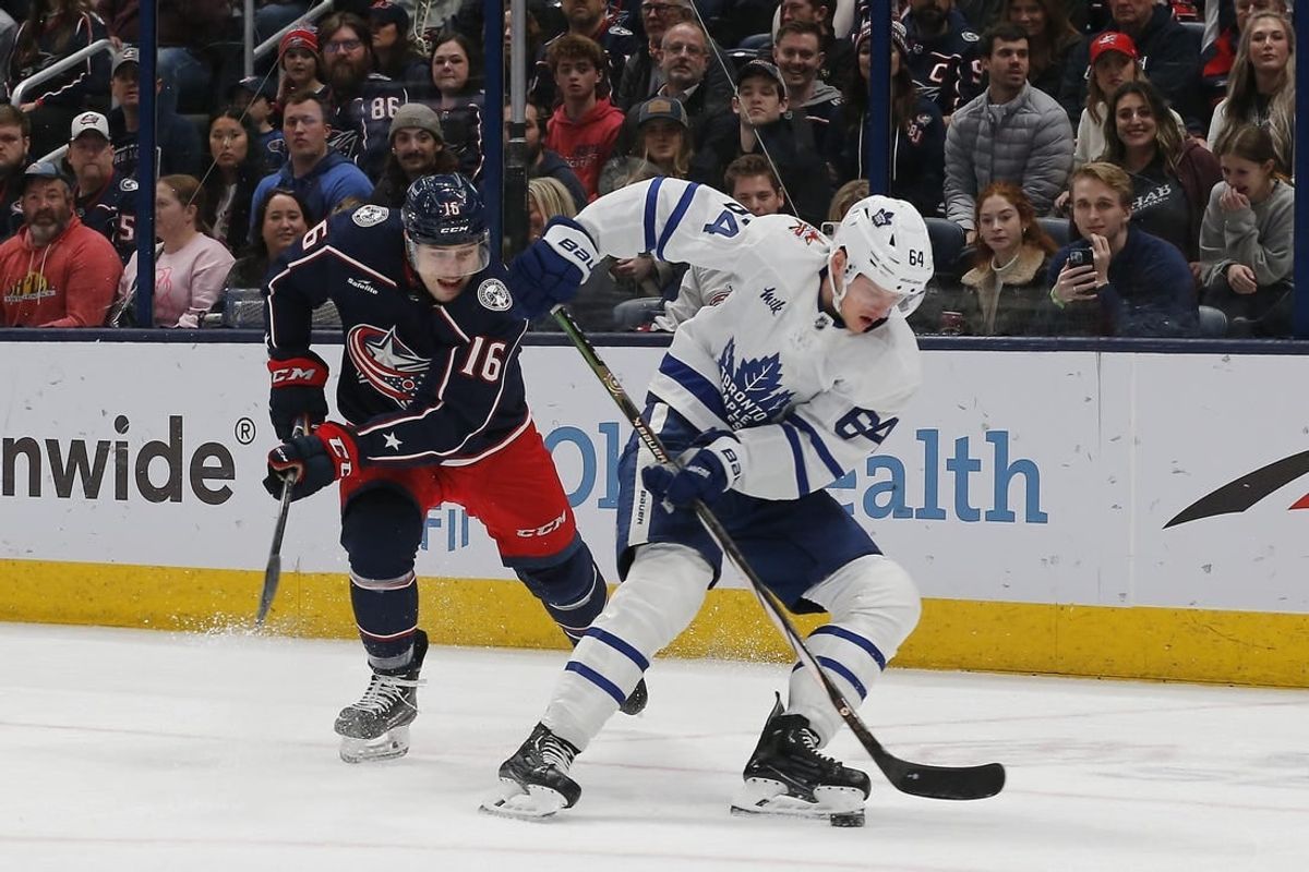 Dec 23, 2023; Columbus, Ohio, USA; Toronto Maple Leafs center David Kampf (64) picks up a loose puck as Columbus Blue Jackets center Brendan Gaunce (16) trails the play during the first period at Nationwide Arena.