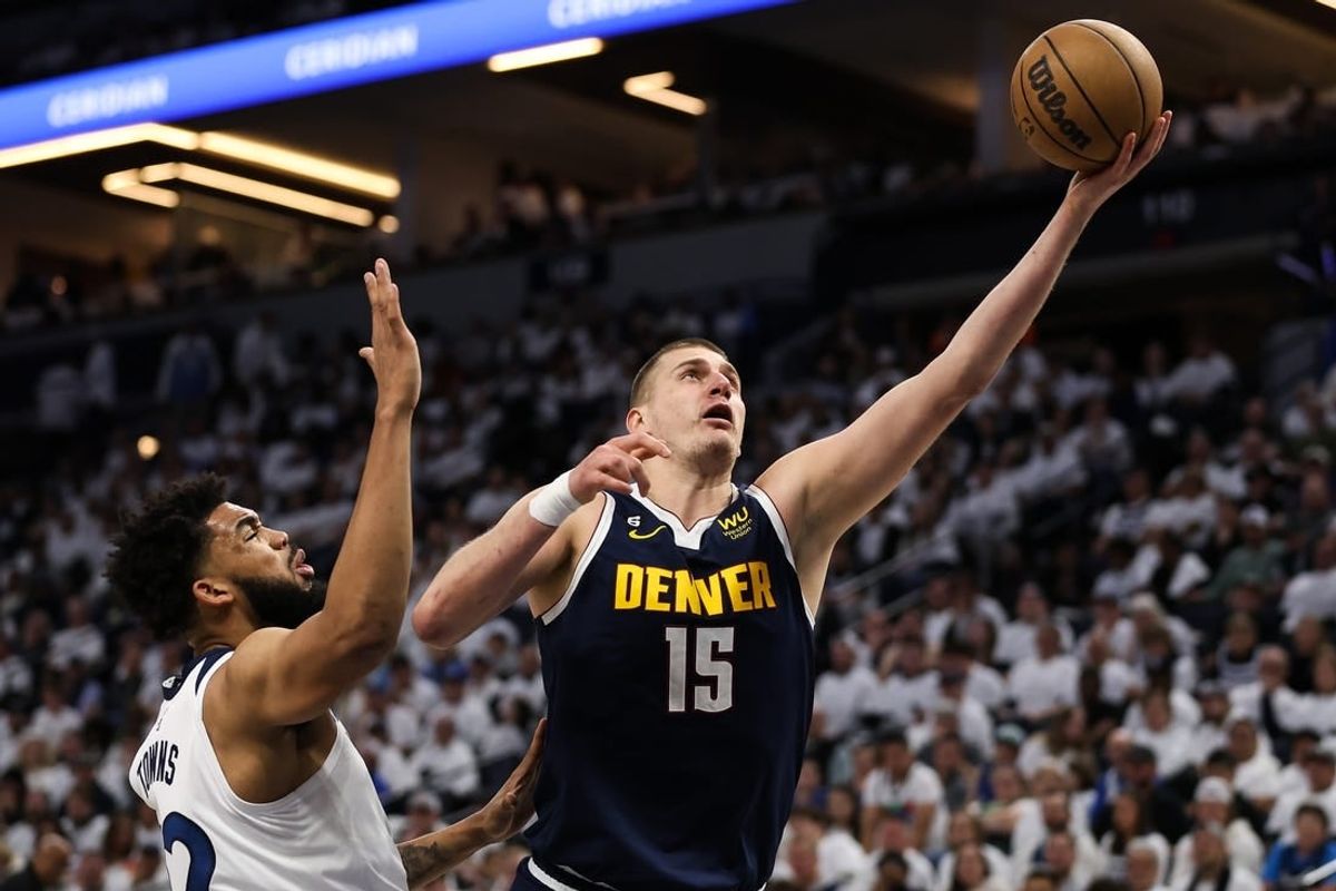 Apr 23, 2023; Minneapolis, Minnesota, USA; Denver Nuggets center Nikola Jokic (15) shoots while Minnesota Timberwolves center Karl-Anthony Towns (32) defends during the second quarter of game four of the 2023 NBA Playoffs at Target Center.