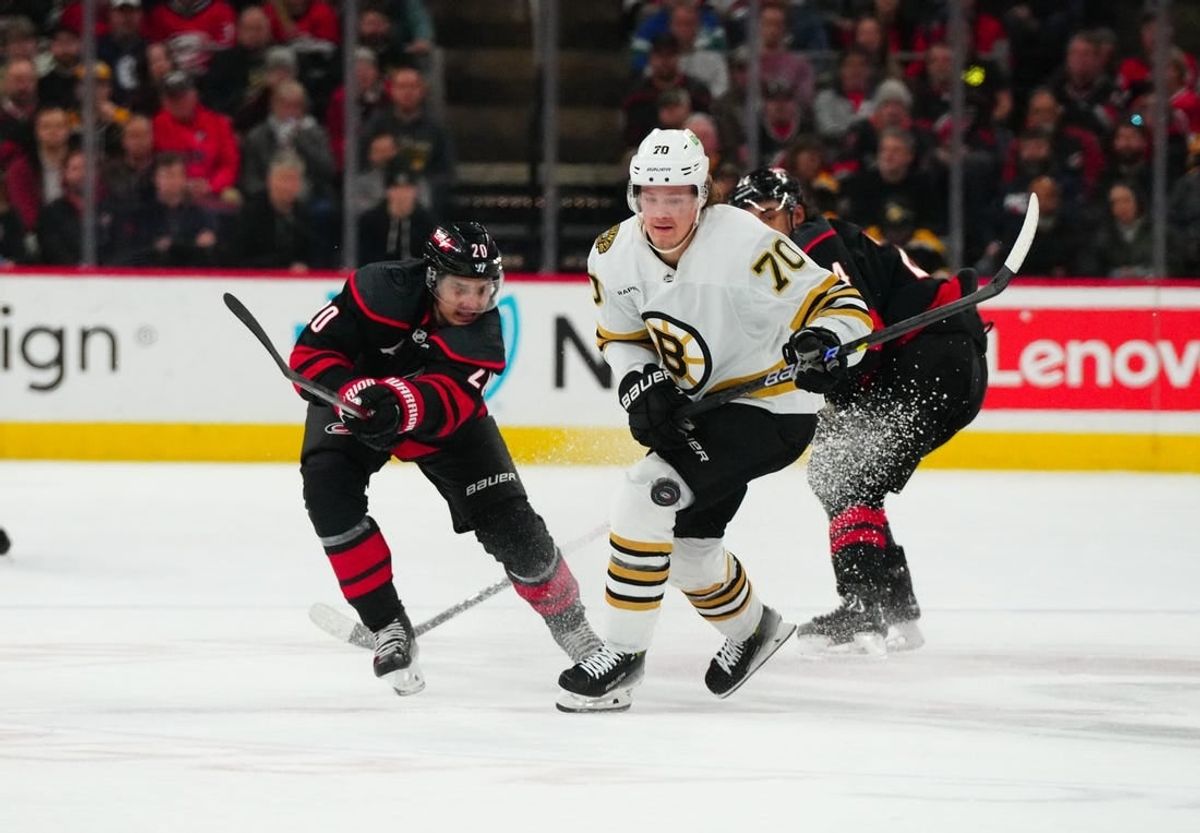 Apr 4, 2024; Raleigh, North Carolina, USA; Carolina Hurricanes center Sebastian Aho (20) and Boston Bruins center Jesper Boqvist (70) watch the puck during the first period at PNC Arena.