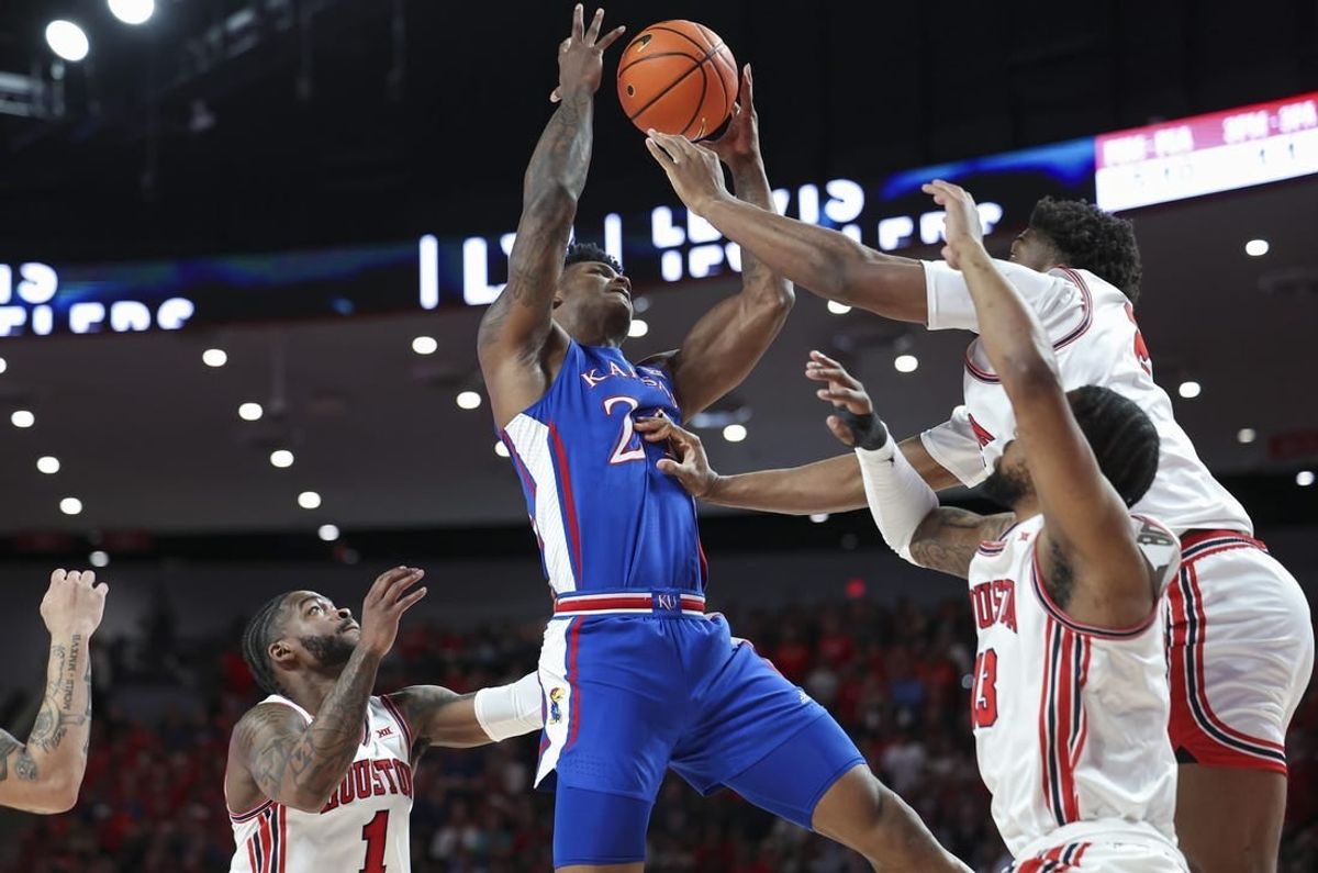 Mar 9, 2024; Houston, Texas, USA; Kansas Jayhawks forward K.J. Adams Jr. (24) attempts to control the ball as Houston Cougars center Cedric Lath (2) defends during the first half at Fertitta Center.