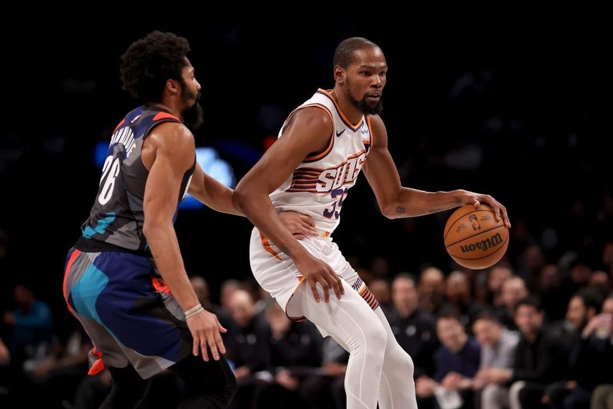 Jan 31, 2024; Brooklyn, New York, USA; Phoenix Suns forward Kevin Durant (35) controls the ball against Brooklyn Nets guard Spencer Dinwiddie (26) during the second quarter at Barclays Center.