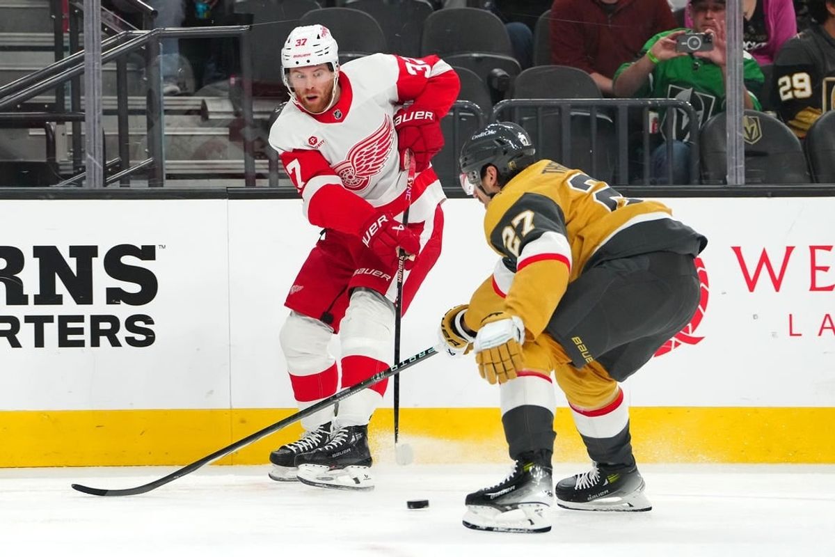 Mar 9, 2024; Las Vegas, Nevada, USA; Detroit Red Wings left wing J.T. Compher (37) makes a pass in front of Vegas Golden Knights defenseman Shea Theodore (27) during the first period at T-Mobile Arena.