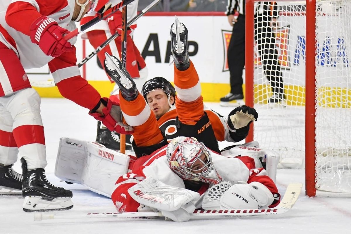 Dec 16, 2023; Philadelphia, Pennsylvania, USA; Philadelphia Flyers left wing Joel Farabee (86) lands on top of Detroit Red Wings goaltender Alex Lyon (34) during the first period at Wells Fargo Center.