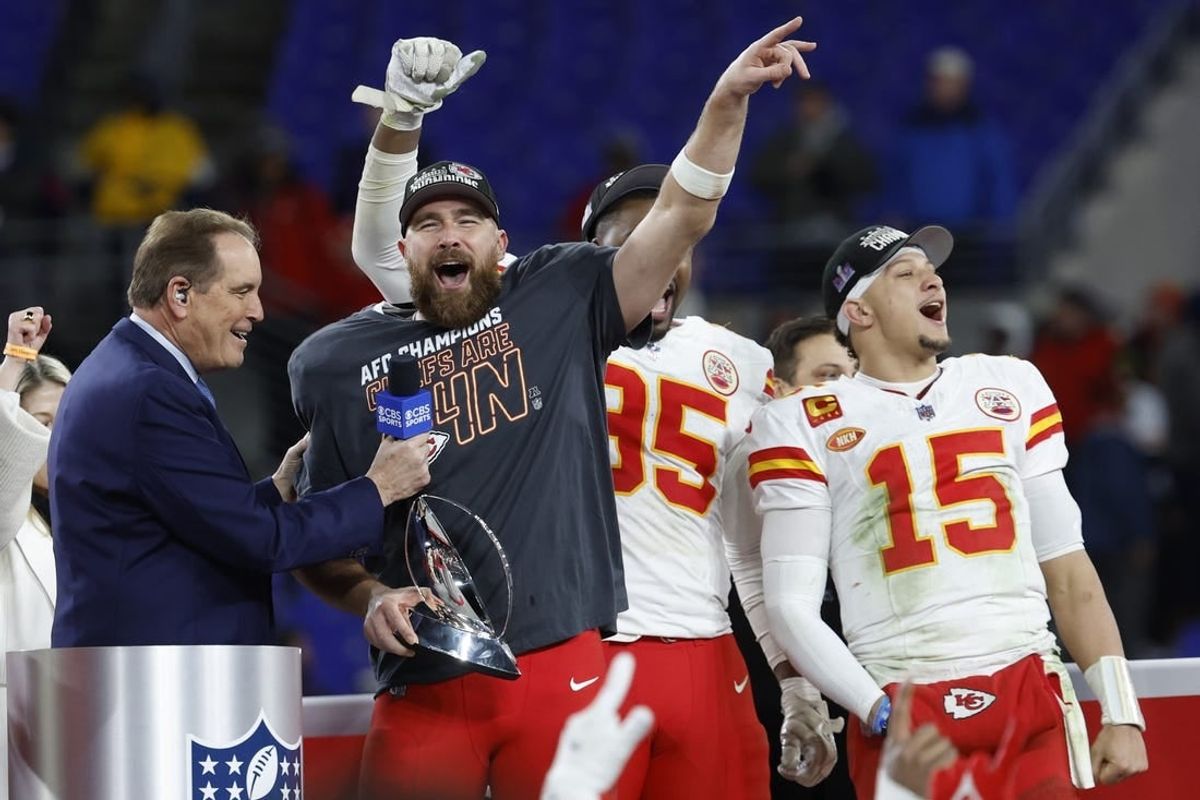 Jan 28, 2024; Baltimore, Maryland, USA; Kansas City Chiefs tight end Travis Kelce (M) celebrates with the Lamar Hunt Trophy while speaking with CBS broadcaster Jim Nance during the trophy presentation after the Chiefs' game against the Baltimore Ravens in the AFC Championship football game at M&T Bank Stadium.