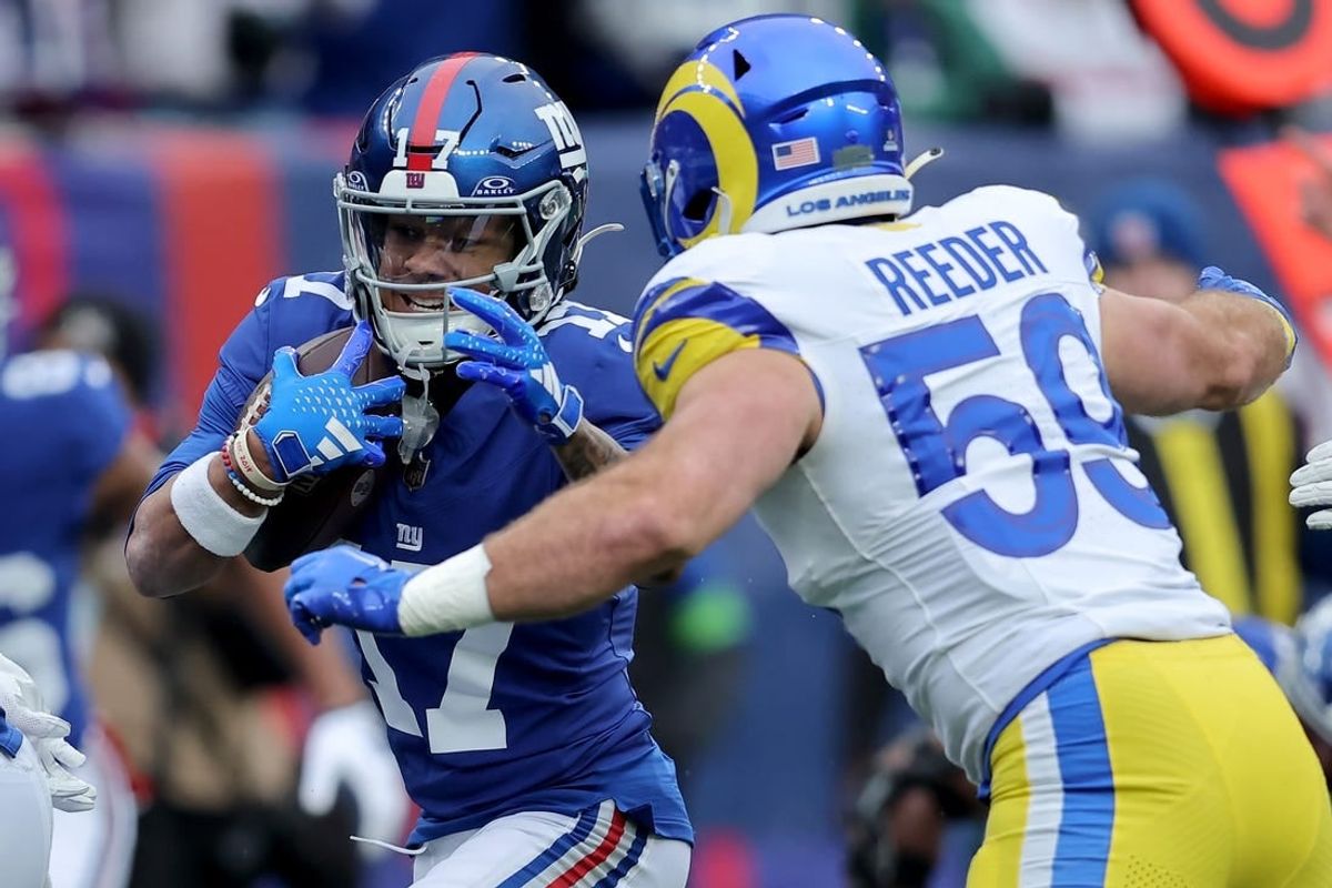 Dec 31, 2023; East Rutherford, New Jersey, USA; New York Giants wide receiver Wan'Dale Robinson (17) runs for a touchdown against Los Angeles Rams linebacker Troy Reeder (59) during the second quarter at MetLife Stadium.
