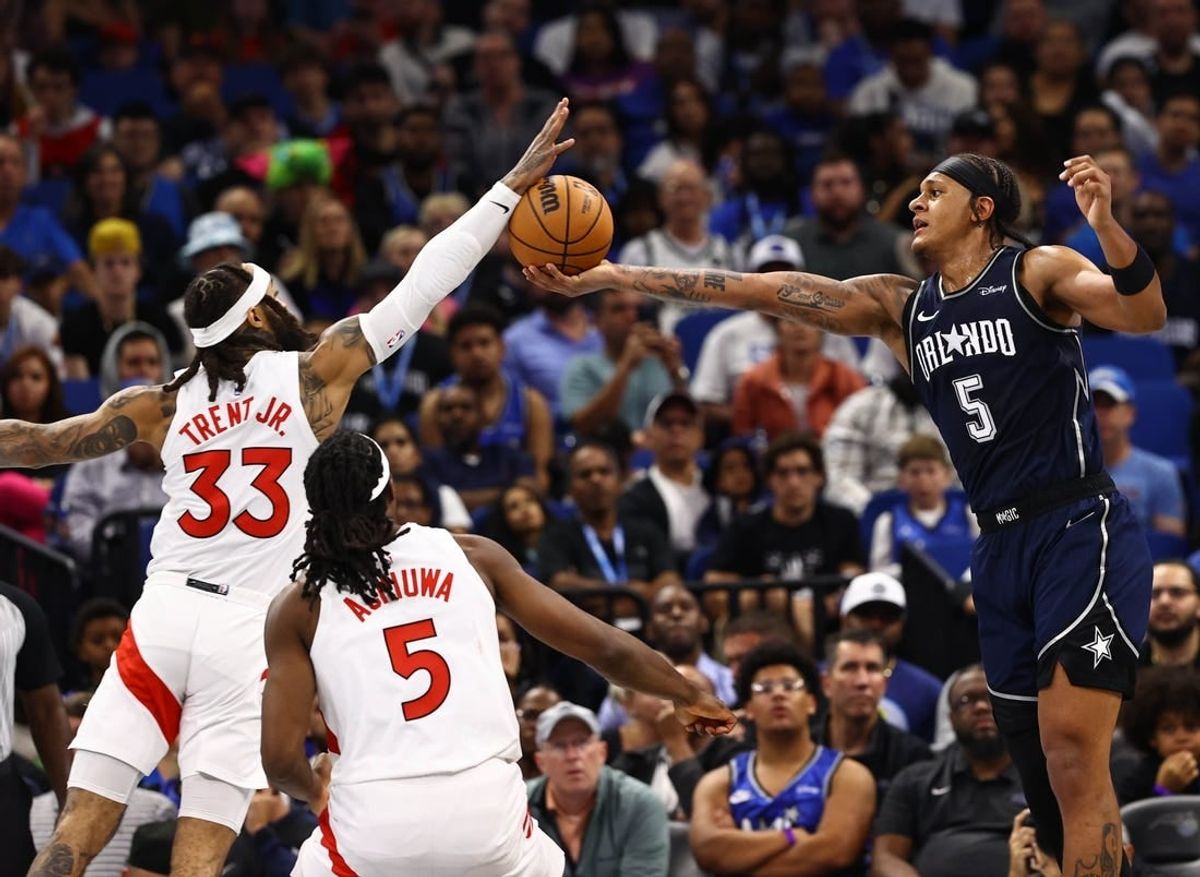 Nov 21, 2023; Orlando, Florida, USA; Toronto Raptors guard Gary Trent Jr. (33) and Orlando Magic forward Paolo Banchero (5) go after the basket during the second half at Amway Center.