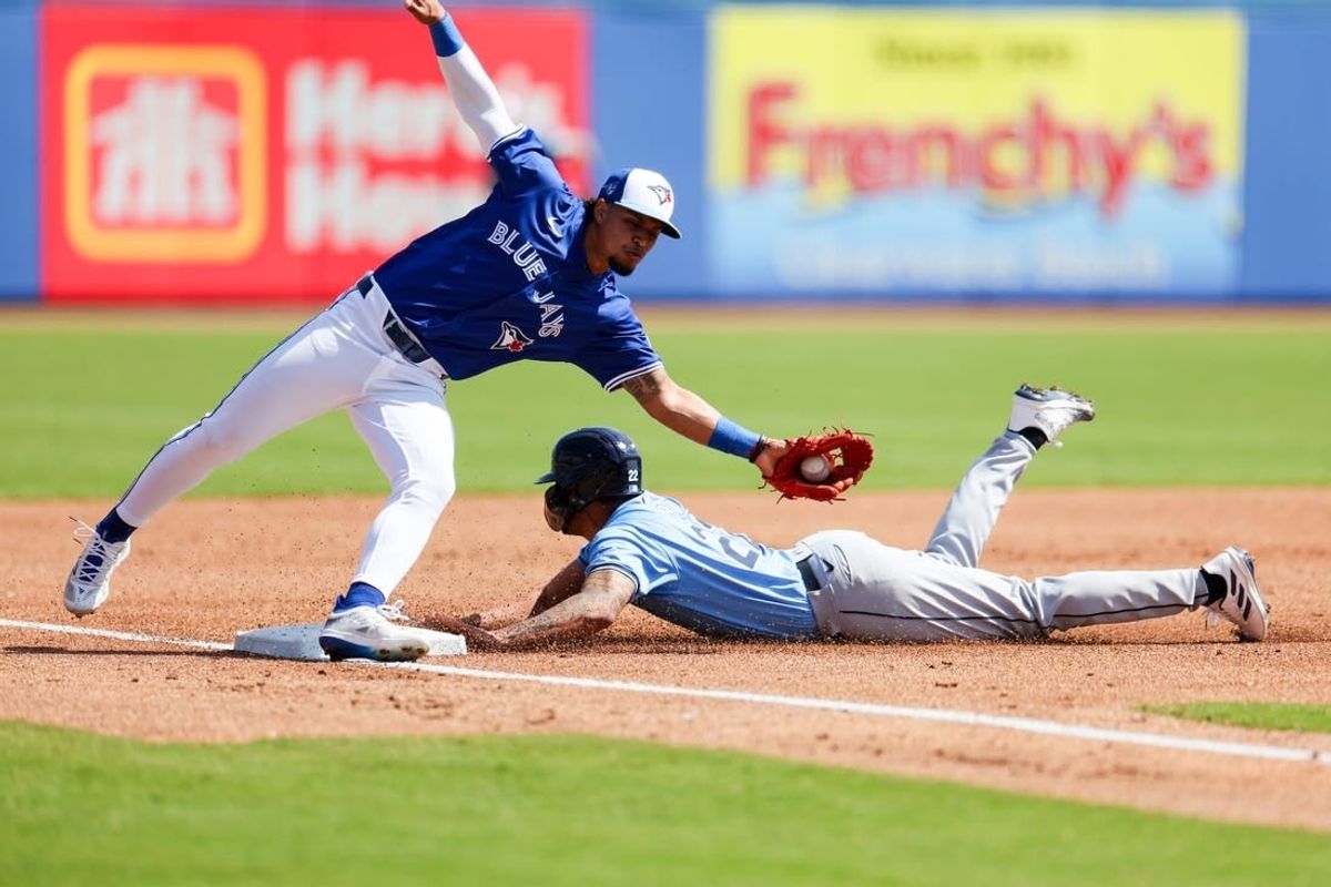 Feb 28, 2024; Dunedin, Florida, USA;  Tampa Bay Rays center fielder Jose Siri (22) steals second base from Toronto Blue Jays third baseman Santiago Espinal (5) in the second inning  at TD Ballpark.