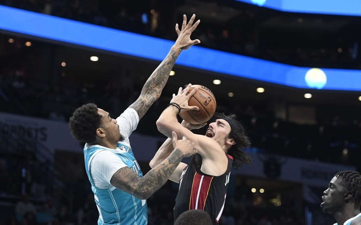Dec 11, 2023; Charlotte, North Carolina, USA; Miami Heat forward Jaime Jaquez Jr. (11) shoots as he is defended by Charlotte Hornets forward P.J. Washington (25) during the first half at the Spectrum Center.