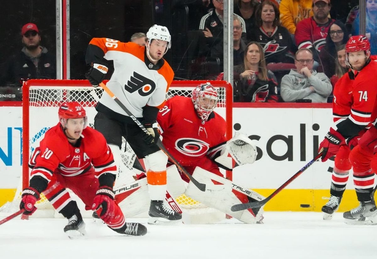 Mar 21, 2024; Raleigh, North Carolina, USA; Carolina Hurricanes goaltender Frederik Andersen (31) and Philadelphia Flyers left wing Joel Farabee (86) watch the shot during the first period at PNC Arena.