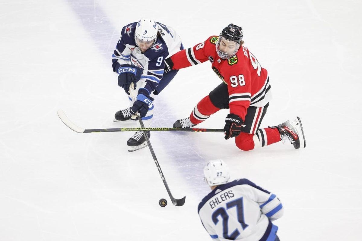 Feb 23, 2024; Chicago, Illinois, USA; Winnipeg Jets left wing Alex Iafallo (9) battles for the puck with Chicago Blackhawks center Connor Bedard (98) during the first period at United Center.